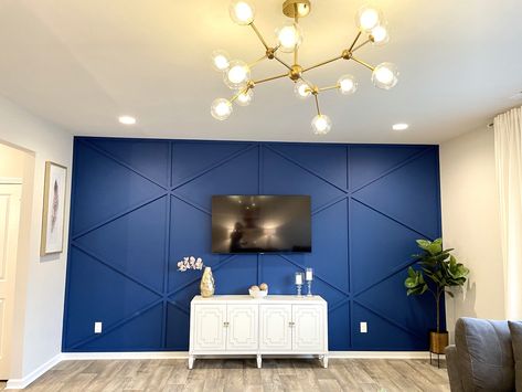 Royal blue geometric accent wall.  This wall is the attraction of this living room.  The spunk chandelier adds some glam to the whole look. Royal Blue Wall Paint Bedroom, Living Room Designs Royal Blue, Royal Blue Accents Living Room, Royal Blue Bedroom Walls, Royal Blue Accent Wall Living Room, Royal Blue Walls Living Room, Royal Blue Accent Wall Bedroom, Royal Blue Wall Paint, Royal Blue Interior Design