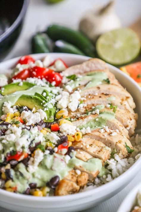 The ultimate fresh and fantastic dinner? Baja Bowls! With tender, full-of-flavor baja chicken over rice, black bean and corn salsa, veggies, and more then smothered in a creamy and tangy cilantro sauce, these baja chicken bowls are irresistible! If you love the Baja Bowl from Panera or Costa Vida, you have to try our at-home version. Baja Bowls, Baja Bowl, Baja Chicken, Black Bean And Corn Salsa, Black Bean And Corn, Chicken Over Rice, Chicken Bowls, Cilantro Sauce, Corn Salsa