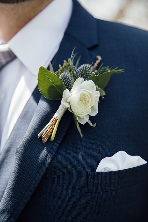 This blue thistle boutonniere with a white flower looked great on this groom's navy suit. Blue Thistle Boutonniere, Blue Corsage And Boutonniere, Boutonniere White Rose, Peach Boutonniere, Whimsical Spring Wedding, Winter Boutonniere, Yellow Boutonniere, Thistle Boutonniere, Red Boutonniere