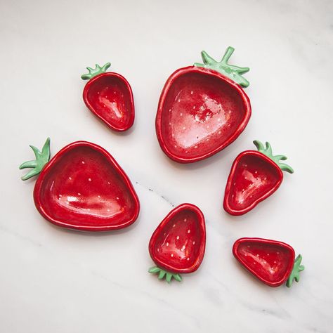 These hand painted ceramic strawberry ring dishes are similar sizes as actual strawberries! No two pieces are exactly alike, ensuring that you have a unique item every time. Enjoy a one-of-a-kind jewelry dish that adds a special touch to your home while offering an elegant solution for organizing your favorite jewelry pieces. Ceramica Artistica Ideas, Ceramic Strawberry, Strawberry Dishes, Strawberry Ring, Air Dry Clay Projects, Clay Diy Projects, Ring Dishes, Pottery Painting Designs, Clay Crafts Air Dry