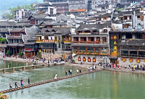 Fenghuang (Phoenix) Ancient City is a very well preserved town with its unique ethnic customs and Ming and Qing architectural styles in the western boundary of Hunan Province.  For the Chinese, the... Gate City, Zhangjiajie, Stone Street, Ancient Buildings, River Boat, China Travel, Ancient Cities, Day Tours, Tour Guide