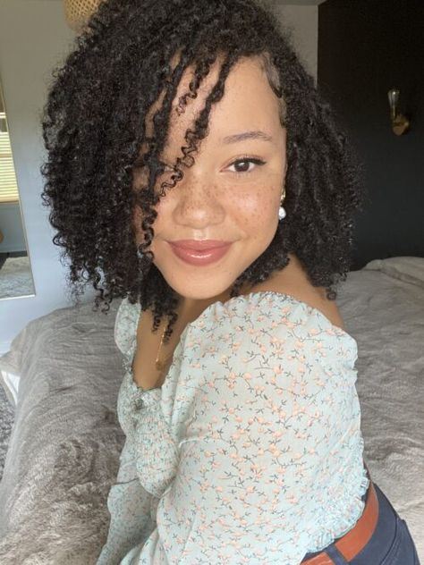 woman with locs sitting on bed smiling at camera. She has freckles and is wearing a light blue shirt with flowers on it. She has a leather brown belt on as well. Natural Curl Locs, Locs On Biracial Hair, Locs Mixed Hair, Locs For Curly Hair, Locs On Type 3 Hair, Real Locs With Curly Ends, Natural Locs With Curly Ends Black Women, Mixed Hair Locs, Frizzy Loc Styles