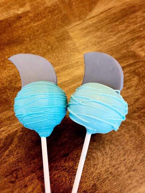 Chocolate and vanilla cake pops dipped in blue and sky blue candy melts and topped with fondants shark fins are a perfect treat for a shark birthday party! Sharkdog Birthday Party, Shark Dog Birthday Party, Sharkdog Birthday, Shark Birthday Party Cake, Shark Dessert Table, Jaws Birthday Party, Shark Party Candy Table, Shark Cakepops, Jawsome Birthday