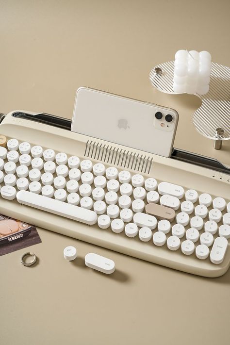 VINTAGE TYPEWRITER KEYBOARD WITH INTEGRATED STAND: The wireless typewriter keyboard includes an integrated stand holder for pad, phone and tablet, which matches the vintage aesthetic of your desk and home office. The retro keyboard also includes adjustable feet, allowing you to set the angle for maximum comfort during long typing sessions. The built-in tablet or phone holder is 13.7 x0.5 inches that can fit most pads. Keyboard Typewriter, Retro Keyboard, Fancy Keyboard, Typewriter Keyboard, Vintage Typewriter, Wireless Keyboard, Bluetooth Keyboard, Vintage Typewriters, Sand Beige