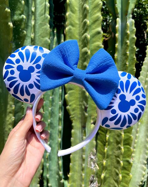 Talavera but make it magical with hidden mouse prints! Made with soft, white velvet  fabric and paired with a royal blue, textured bow for a more culturally representative feel! On each ear you can find a one-of-a-kind hand sketched talavera design with a mouse silhouette in the center, transferred onto royal blue vinyl. Celebrate Cinco de Mayo at the parks or proudly represent in our Terra-Mex Talavera Azul ears! ✦The placement and pattern of vinyl will slightly vary from each handmade pair, ad White Velvet Fabric, Talavera Design, Disney Bound Outfits Casual, Diy Disney Ears, Mouse Silhouette, Disney Minnie Mouse Ears, Disney Headbands, Disney Mickey Ears, Floral Wallpaper Iphone