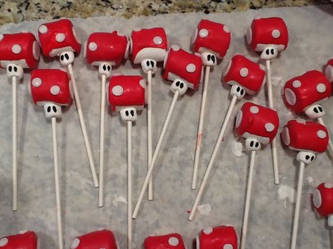 Mario "Toad" marshmallow pops  I used one regular sized marshmallow for the head and a mini marshmallow for the face.  The head was dipped in red chocolate Wilton chocolate melts.  While they were cooling I rolled out white fondant.  I used the large circle decorating tip (again this was Wilton) for the circles and attached them to the dried red chocolate using water.  I allowed this to set up and once done, I drew the eyes on using a candy writer.  The kids at the Mario party loved these!! Mario Chocolate Covered Strawberries, Mario Toad, Covered Marshmallows, Chocolate Melts, White Fondant, Chocolate Covered Marshmallows, Red Chocolate, Super Mario Birthday, Marshmallow Pops