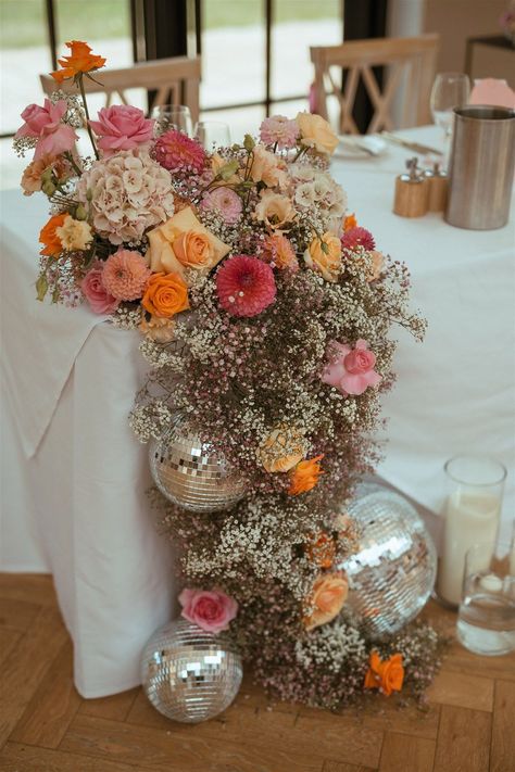 Pink and orange wedding flower decorations with gypsophila, roses, dahlias and more with disco balls Pink And Orange Wedding, Disco Ball Decorations, Retro Wedding Theme, Flower Cloud, Wedding Sunglasses, Disco Theme, Pear Tree, Ball Decorations, Wedding Flower Decorations