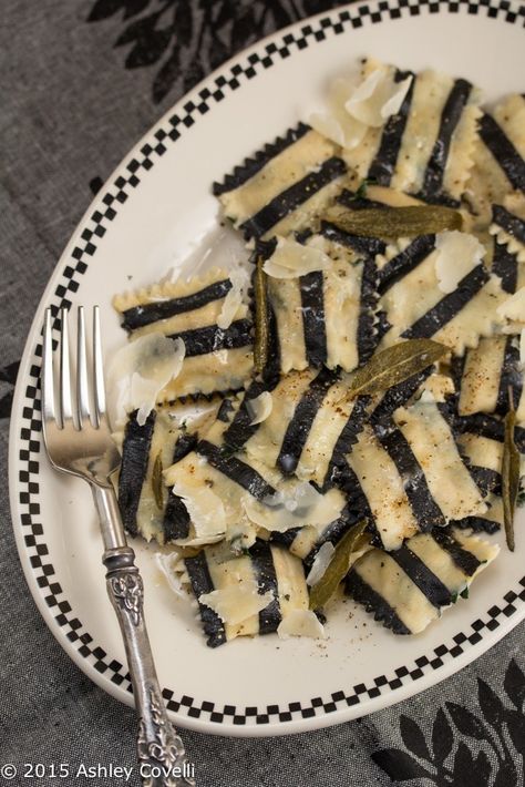 Homemade black and white striped pasta is stuffed with roasted veggies and topped with brown butter sauce and crispy sage leaves. Beetle Juice Dinner Party, Beetlejuice Recipe, Vampire Banquet, Beetlejuice Dinner Party, Striped Pasta, Goth Picnic, Black And White Halloween Party, Sweet Potato Ravioli, Goth Food