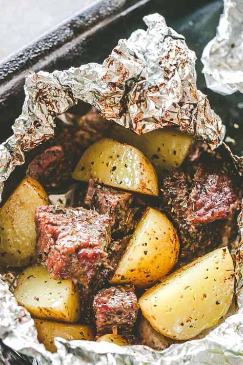 Delicious steak & potatoes recipe! Seasoned with garlic and herbs, then cooked inside foil packets this recipe is perfect for camping, grilling or the oven. #steak #potatoes #foilpacks #camping #grilling #cookout #outdoorcooking Garlic Herb Steak, Steak Foil Packets, Foil Pack Recipes, Foil Packet Potatoes, Foil Meals, Seared Salmon Recipes, Foil Pack Dinners, Fantastic Recipes, Foil Packet Dinners