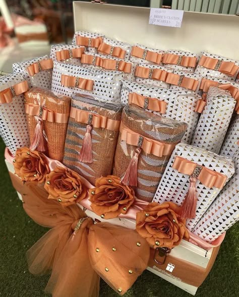 Wax print cloths wrapped in orange, peach and white theme for engagement dowry wrapping Engagement Preparation, Dowry Decoration, Peach Christmas, Acceptance Letters, Traditional African Wedding, Engagement Gift Baskets, Return Gift Ideas, Lace Styles For Wedding, Wedding Packaging