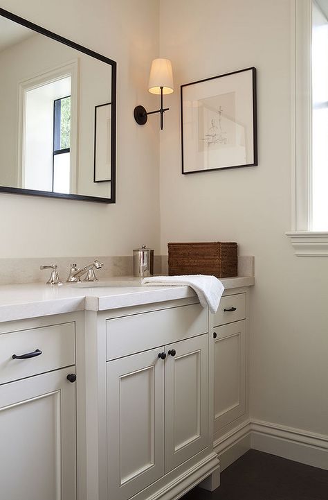 Cream powder room features a cream vanity adorned with bronze knobs placed under… Bathroom Ideas Cream, Cream Bathroom Vanity, Cream Bathroom Ideas, White And Cream Bathroom, Black And Cream Bathroom, Cream Bathroom, Farmhouse Bathroom Vanity, Vanity Ideas, Transitional Bathroom