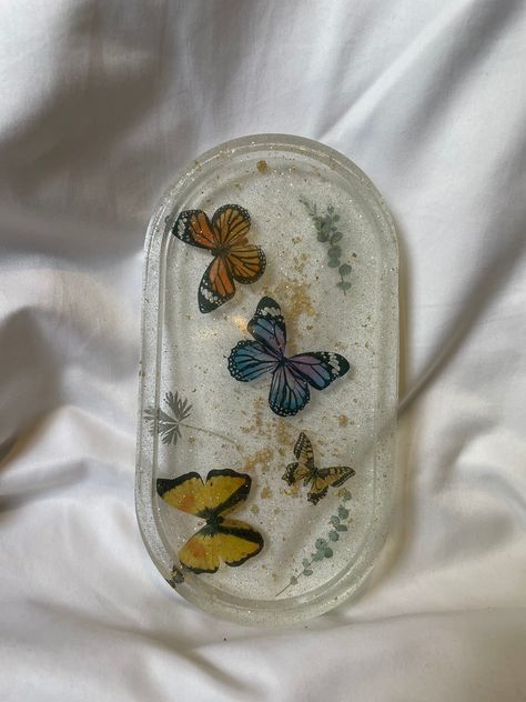 A hand crafted resin ash tray with (fake) butterflies and plants encased inside. Fake Butterflies, Resin Butterfly, Bugs Life, Living Essentials Oils, Resin Ideas, Living Essentials, Ash Tray, Candle Business, Diy Resin Art