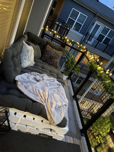 Diy Balcony Bed, Balcony Couch Diy, Balcony Decor With Lights, College Apartment Patio Decor, Affordable Balcony Ideas, Fake Plants Patio Decor, Diy Balcony Couch, Pallet Bed Balcony, Pallet Couch Outdoor Balcony