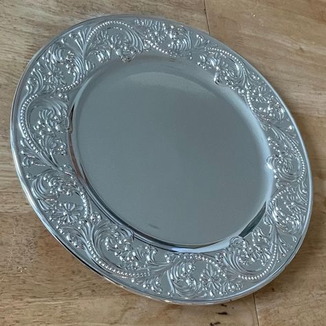 ELEGANT DESIGN: Stunning silver charger plate featuring an intricately embossed floral and scroll pattern border that adds sophistication to any table setting PREMIUM SIZE: Measures 33 centimetres in diameter, providing an ideal backdrop for dinner plates and special occasion place settings VERSATILE USE: Perfect as a decorative base plate for formal dining, special events, weddings, or as an elegant display piece LUXURIOUS FINISH: Polished silver-tone surface reflects light beautifully and coordinates seamlessly with various dinnerware styles Silver Charger Plates, Silver Chargers, Scroll Pattern, Polish Silver, Charger Plates, Dining Table Decor, Formal Dining, Decoration Table, Dinner Plates