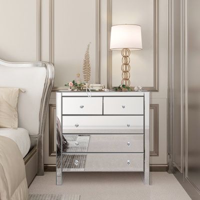 Elevate your storage solutions with HomeBelongs 5 - Drawer Mirrored modern and sleek accent chest of drawers. Designed with clean-cut lines and practicality in mind, this piece offers ample storage space for your clothing and accessories. Each of the five drawers features a charming crystal-effect handle, adding a touch of elegance to its functional beauty. The drawer height is 6", width is 30" and depth is 15''. The largest drawer can support up to 25 lbs. providing a secure spot for your belon Mirror Drawers Bedrooms, Mirrored Furniture Bedroom, Mirrored Dresser Bedroom, Mirrored Nightstand Bedroom, Mirrored Dresser, Mirror Dresser, Glam Bedroom Decor, Mirror Drawers, Wide Chest Of Drawers