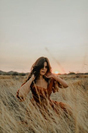 woman-sitting-in-tall-grass Y’all Grass Photoshoot, Dry Grass Photoshoot, Wheat Grass Photoshoot, Grassland Photoshoot, Tall Grass Senior Pictures, Stool In Field Photoshoot, High Grass Photoshoot, Long Grass Photoshoot, Grass Photoshoot