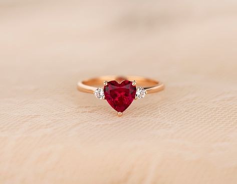 ♦ Handmade, high-quality item ♦ Material: 14K SOLID Rose Gold (can be made in Solid white/rose/yellow gold) ♦Finish: High Polishing Finish with Rhodium platting ♦ Center stone: Lab Created Ruby Heart ♦ Size/Weight: Heart 7*7mm / Approx 1.25 ct ♦ Side stones: Simulated Diamonds (CZ) ♦ Cut - Round 2.5mm ♦ Color Option: White Diamonds: D / Cognac Diamonds: C2 ♦Clarity: VVS1 ♦Cut Grade: Excellent ♦ Width of band bottom - 1.8 mm ♦ Thickness of the gold band - 1.2 mm Ring Designs Ruby, Rings Heart Shaped, Ruby Jewelry Ring, Ruby Ring Designs, Ruby Heart Ring, Heart Shape Ring, Hand Jewelry Rings, Sapphire Engagement Ring Set, Heart Promise Rings