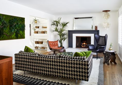 Living Room Design with Milo Baughman houndstooth sofa, Moroso Diesel chair, Vintage Falcon Chair, West Elm rug, Artisan on the Wall preserved greenery art, vintage wedding stool, vintage capiz chandelier, and gas fireplace. Design by Ann Gottlieb Design; Photography by Stazy Zarin Goldberg Houndstooth Sofa Living Rooms, Houndstooth Sofa, Gas Fireplace Design, Houndstooth Chair, Falcon Chair, West Elm Rug, Greenery Art, Capiz Chandelier, Black And White Chair