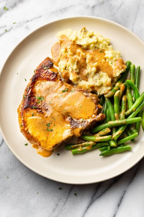 Smothered pork chops are easy to make and incredibly comforting. Use bone-in or boneless pork chops. This delicious family dinner is quick to prepare! They're perfect with mashed potatoes for all that gravy. Best Smothered Pork Chops, Easy Smothered Pork Chops, Pork Chops Bone In, Smothered Pork Chops Recipe, Pork Chops And Gravy, Pork Chops And Potatoes, Smothered Pork, Delicious Family Dinners, Apple Pork