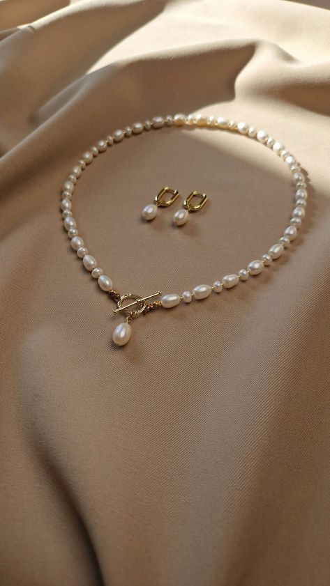 Elevate her neckline with our stunning natural pearl jewelry set. This gorgeous freshwater pearl toggle necklace adorned with a single radiant pearl, symbolizes purity and elegance. The toggle design adds a contemporary twist to this timeless piece, making it a versatile addition to her jewelry collection Looking for the perfect Mother's Day gift for mom or anniversary gift for wife, or special gift for any other important women in your life. Our real pearl jewelry set speaks volumes of love and Classy Pearl Jewelry, Pearl Set Designs, Pearl Necklace Designs Unique, Real Pearl Jewelry, Pearls Jewellery, Real Pearl Jewellery, Pearl Necklace And Earrings, Natural Pearl Jewelry, Necklace Packaging