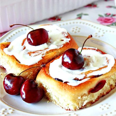 This homemade Cherry Sweet Rolls recipe makes light-as-air yeasty breakfast buns with delicious cherry flavor along with a thick topping of sweet almond glaze. #cherryrecipe #cherrybuns #cherrysweetrolls #sweetrolls #sweetbreakfastrolls #sweetbrunchrecipe #cherries #almondglaze #yeastrolls #sweetyeastrolls #homemadesweetbuns #creamcheeseglaze #kudoskitchenrecipes Pioneer Woman Glazed Cherry Almond Rolls, Cherry Sweet Rolls Recipe, Cherry Sweet Rolls, Cherry Rolls, Sweet Rolls Recipe, Almond Cream Cheese, Breakfast Buns, Almond Glaze, Glazed Cherries