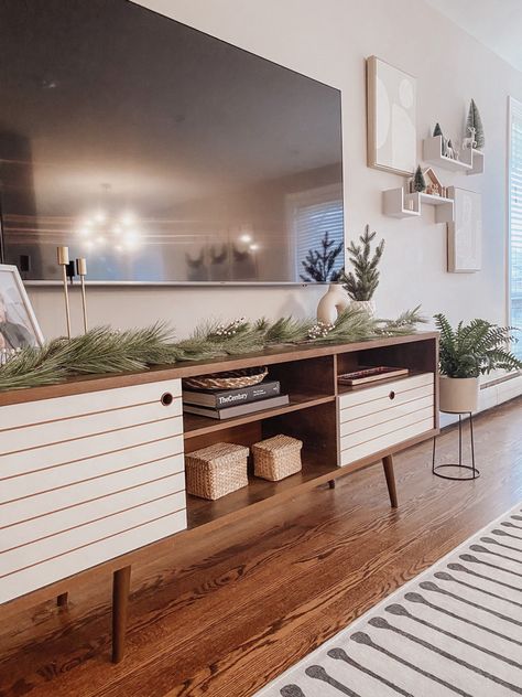 Greenery On Tv Stand, Living Room Designs With Tv Stand, Picture Frames On Tv Stand, Styling Tv Stand Living Rooms, Long Tv Stand Decor, Winter Tv Stand Decor, Holiday Tv Stand Decor, Tv Stand Holiday Decor, Boho Living Room Tv Stands