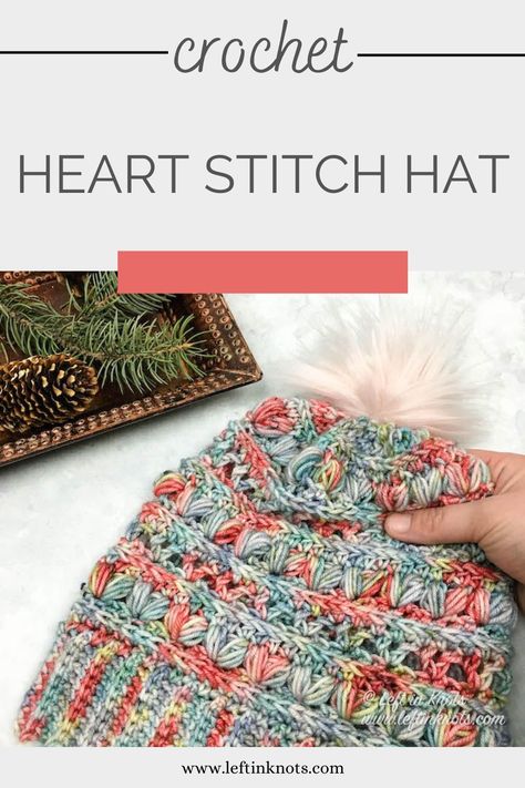 A crochet beanie that uses puff stitches to create rows of hearts.  The yarn is hand dyed and multicolor with coral, blue, green, and gray.  The hat is toped with a light pink pom pom. Crochet Pikachu, Crochet Presents, Crocheted Beanies, Crochet Headwear, Crocheted Ideas, Crocheted Clothing, Crochet Valentines, Heart Stitch, Crochet Garments