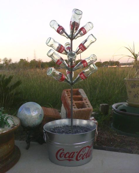 Coca-Cola Coke Bottle Tree.  Made from rebar and embedded in concrete. Old Coke Bottles Ideas, Old Coke Bottles, Coke Bottle Crafts, Bottle Tree, Bottle Ideas, Wine Bottle Art, Bottle Garden, Outdoor Decorating, Coke Bottle