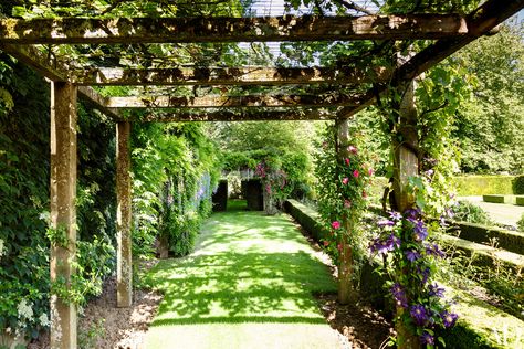 This teak pergola features a wide array of blooms—the grapevines that blanket the top of the structure shade red roses and purple clematis, providing just the right amount of light. The arch beyond is draped with wisteria. Read on for more pergolas and trellises for spring. Shade Landscape, Shade Pergola, French Country Estate, Vinyl Pergola, Small Pergola, Pergola Diy, Garden Pergola, Support Columns, Patio Pergola