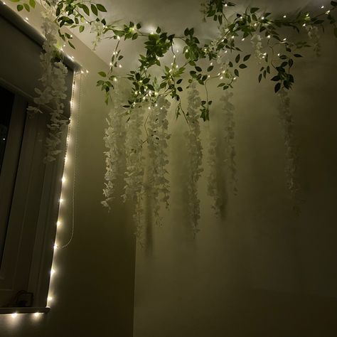 Celling decorated with white wisteria flowers and fairy lights. Night time. Ivy Fairy Lights Living Room, White Wisteria Bedroom Decor, Bedroom Decor Ideas Fairy Lights, Bedroom Ceiling Ideas Diy Fairy Lights, Wisteria Corner Bedroom, Wisteria On Ceiling Bedroom, Hanging Flower Vines, Vine Lights On Ceiling, Wisteria Fairy Lights