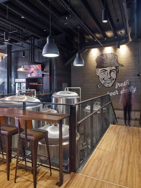 This industrial inspired brew pub and restaurant design features a large wall mural and glimpses of the beer making equipment. Microbrewery Design, Brewery Bar Design, Brewery Interior, Aviation Gin, Industrial Office Decor, Brewery Bar, Brewery Design, Pub Interior, Beer House