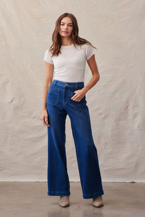 Switch up your sweatpants with these versatile Lola wide leg jeans. We love their vintage 70's flair and how cute they look with everything. The design features two front pockets and wide leg hems. Style these with a nice blouse and platforms for an elevated look or espadrilles and a cropped tee for a casual look. Either way these will become your favorite jeans! Made with 100% Ecovero. Made in Los Angeles 100% Ecovero Machine wash cold Two front pockets High waisted style Wide leg hems Model is Wide Fit Jeans Outfit, Navy Jeans Outfit, Wide Leg Dark Jeans, Dark Washed Jeans Outfit, Flair Jeans Outfit, Dark Jeans Outfit, Wash Jeans Outfit, Flare Jeans Style, Flair Jeans