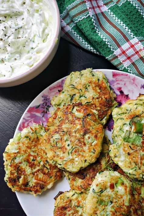 Greek Courgette Fritters with feta, or Kolokithokeftedes, a delicious and healthy summer appetizer that is quick and easy to make with fresh seasonal ingredients. The fritters are shallow fried for a crispy texture, and are served with a refreshing tzatziki sauce. Courgette Fritters, Courgette Fritter, Tasty Beef Stew, Greek Appetizers, Veggie Patties, Beef Skewers, Summer Appetizer, Tzatziki Sauce, Seasonal Ingredients