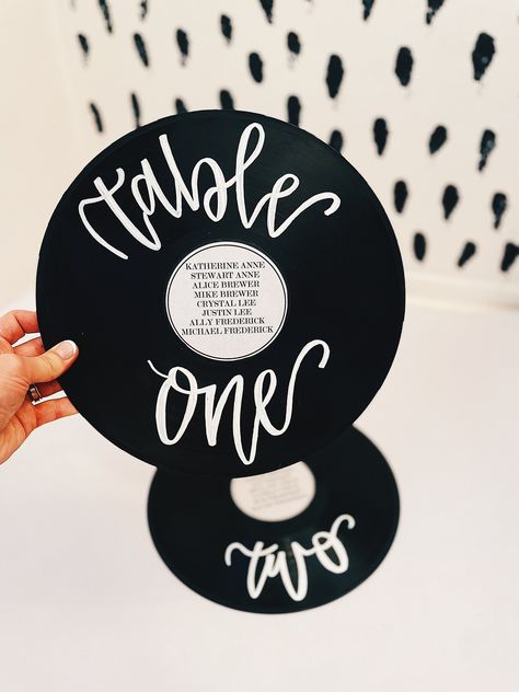 Elevate your event with our customizable vinyl record table seating chart, blending retro charm with contemporary elegance. Each vinyl record is transformed into a unique seating chart, featuring table numbers written in modern calligraphy and guest names printed on a center label. Perfect for weddings, anniversaries, or any special event, these seating charts add a touch of vintage flair while guiding your guests to their seats in style. **Features - **Authentic Vinyl Records Each seating chart Record Table Plan, Vinyl Record Seating Chart, Alternative Wedding Decor, Record Table Numbers, Record Seating Chart, Creative Seating Chart Wedding, Retro Modern Wedding, Vinyl Record Table, Vinyl Record Wedding