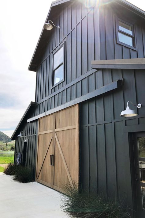 Black farmhouse with galvanized lighting from Barn Light Electric Farm Light, Barn Light Electric, Barn Shop, Barn Renovation, Black Barn, Modern Barn House, Barns Sheds, Barn Light, Barn Design