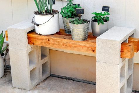 We built a cinder block plant stand to match our DIY cinder block bench and cinder block raised garden bed. The gray of the cement blocks and the rustic wood look great with our recent French country budget patio makeover, and cinder blocks are really cheap and easy to work with, making this DIY concrete block bench a quick, easy, and budget-friendly project. Visit FabEveryday.com for the cinder block plant bench instructions and what you need to create a bench made from cinder blocks and wood. Concrete Block Plant Stand, Easy Patio Diy, Cinder Block Garden Table, Raised Garden Bed Area, Cinder Block Table Outdoor, Cement Block Bench, Concrete Block Bench, Cinder Block Plant Stand, Lanai Decor