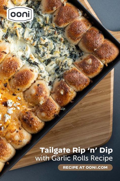 Every party needs a show-stopping dish, and our Tailgate Rip ‘n’ Dip with Garlic Rolls is precisely that. Here, we bake Buffalo chicken and spinach artichoke dips inside a pull-apart garlic knot crust for an appetizer that’s creamy, spicy and garlicky all at once. We put them in a rectangular Sicilian pan, but any heatproof 8-by-10-inch baking dish will work just as well. For the dips, we went with game night classics: spinach artichoke and Buffalo chicken. 4 Dips One Pan With Pizza Dough, Ooni Recipes, Cheesy Spinach Artichoke Dip, Garlic Knot, Ooni Pizza, Pizza Oven Recipes, Spicy Buffalo Chicken, Garlic Rolls, Buffalo Chicken Recipes