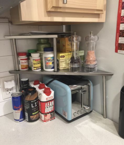 A two-tier kitchen corner shelf that'll turn that one corner of the kitchen where the toaster lives into a multitude of storage options. Kitchen Corner Shelves, Kitchen Countertop Storage, Organization Design, Countertop Decor, Storage Products, Countertop Storage, Home Storage Solutions, Kitchen Corner, Cabinet Storage