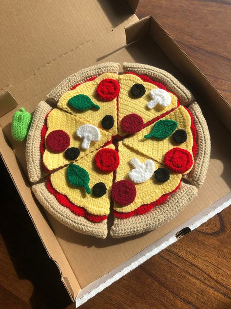 This hand crocheted pizza is a fun, adorable toy for any child! Included in this toy are six of each of the following: pizza crust, sauce, cheese, pepperonis, tomatoes, onions, black olives, spinach leaves, and mushrooms. It also comes with a pepperoncini pepper and is packaged in a customizable pizza box. This toy allows for hours of creative play and makes the perfect addition to any play kitchen or play restaurant! Pizza Crochet, Crochet Pizza, Crochet Kids Toys, Kids Play Set, Crochet Fruit, Confection Au Crochet, Crochet Food, Crochet Purse Patterns, Crochet Tapestry