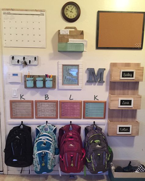 Finished my command center/backpack wall! Mail rack and wooden file rack from HomeGoods. Calendar, clock, cork board, frames from Walmart. Metal letter from Amazon. I made the key rack, jar holder, and backpack rack. So happy with how it turned out! Backpack Wall, Home Command Center, Family Command Center, Command Center, Home Organisation, Family Organizer, Organization Kids, School Organization, Office Organization