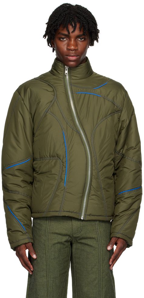 Insulated quilted polyester taffeta jacket. Piping in blue throughout. · Paneled and layered construction · Stand collar · Asymmetric zip closure · Zip pockets · Bungee-style drawstrings at hem · Fully lined · Contrast stitching in blue Supplier color: Green Climbing Fashion, Sports Day Outfit, Mens Jacket Pattern, Arcteryx Jacket, 90s Activewear, Taffeta Jacket, Quilting Fashion, Unisex Streetwear, Zipper Fashion