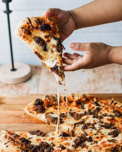 Looking for a delicious way to use your leftover birria de res? Make super cheesy birria pizza! Using my classic chewy pizza crust recipe brushed with melted garlic butter, it's topped with juicy beef birria, super flavorful consommé, and tons of oaxaca cheese. This is a family friday movie night favorite at our house! Continue reading Birria Pizza at Sweet Tea + Thyme. Leftover Birria, Chewy Pizza Crust, Birria Pizza, Birria Recipe, Weekday Recipes, Homemade Honey Butter, Beef Birria, Honey Butter Chicken, Friday Movie