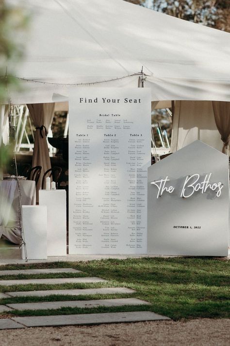 wedding reception white table seating chart with black vinyl and acrylic lettering in the centre, a small sign showcasing a personalised neon sign to the right and two textured plinths to the left White Seating Chart, Wedding Reception Seating Chart, Spring Wedding Reception, Seating Chart Wedding Diy, Wedding Table Seating Chart, Romantic Spring Wedding, Reception Seating Chart, Long Table Wedding, Wedding Guest Table