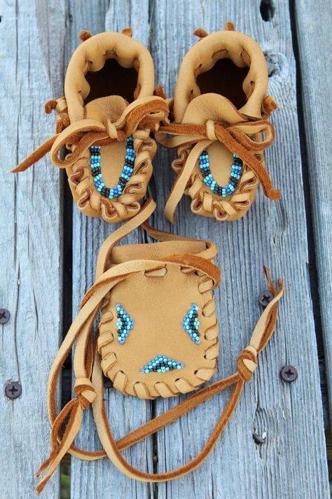 A baby moccasins gift set for a baby boy. This listing includes a pair of 3 to six month old handmade baby moccasins and a small beaded drawstring pouch, 2.75 inches tall and 2 inches wide. These baby moccasins are made in soft saddle tan  leather . The leather is very soft and durable. Leather baby moccasins make a sweet keepsake for generations to come and a perfect baby shower gift for a new mom and baby. They measure 4 inches heel to toe. Check out size variations > Newborn > 3.5 inches heel Mukluk Pattern, Diy Baby Moccasins, Beaded Baby Moccasins, Gnome Shoes, Baby Boy Moccasins, Moccasin Patterns, Baby Moccasin Pattern, Diy Moccasins, Beading Flowers