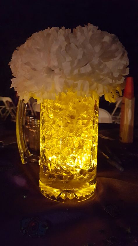 Beer centerpiece.  Cubes from M2 polymer. LED submersible from Amazon. Mug from Dollar Tree. 7 silk carnation. Foam piece for carnations. 40th Bday Table Centerpieces, Beer Mugs Centerpieces, Simple Mens Birthday Decorations, Beer Glass Centerpiece, Modelo Beer Centerpieces, Cheers And Beers Centerpiece, Beer Mug Centerpiece Table Decorations, Beer Table Decorations, Cheers And Beers 50th Birthday Party