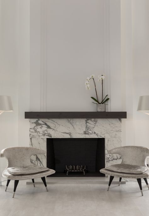 Tesoro Bianco Dolomite Fireplace project created using Dolomite Marble slabs from Primestones®, Premier Stone Provider in South Florida with locations in Miami and WPB. #tesorobianco #tesorobiancodolomite #bathroom #bathroomdecor #naturalstonecountertop #naturalstoneflooring #naturalstone #bathroominspiration #interiordesign New Classic Fireplace, Electric Fireplace With Marble Surround, Marble Fireplace With Wood Mantle, Marble Fireplace With Mantle, Marble Fireplace Ideas Modern, Marble Surround Fireplace, Classic Fireplace Ideas, Fireplace Ideas Marble, Marble Slab Fireplace