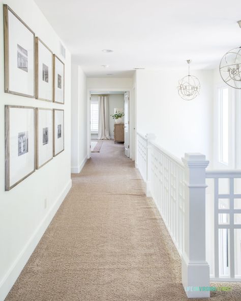 A photo gallery wall in a hallway with walls painted Benjamin Moore Simply White and silver orb chandeliers. Hallway Photo Gallery, Photo Gallery Wall, Hallway Gallery, Hallway Gallery Wall, Life On Virginia Street, Summer Living Room, Above Kitchen Cabinets, Wall Inspiration, Upstairs Hallway