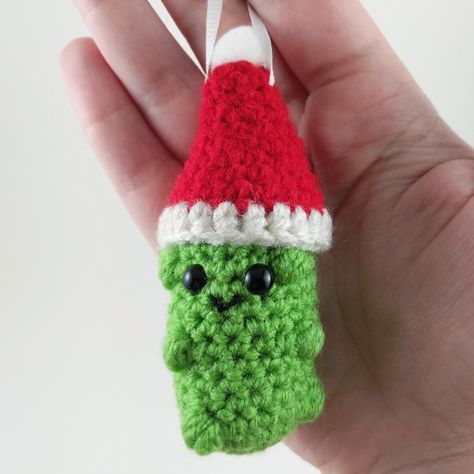 This cute and fun Christmas pickle ornament is sure to get a laugh from family and friends.  The pickle body is made using a combination of single crochet and puff stitch to make the little "pickle bumps".  This pickle is made using continuous rounds for the pickle body, and the hat is made with joined rounds.  Fairly quick to make, the pickle can be finished in 1-2 hours.  Hat can either be sewn on or glued on, as well as the pom-pom - whichever method you prefer. Crochet Octopus Pattern, Christmas Pickle Ornament, Crochet Pants Pattern, Positive Potato, Pickle Ornament, Octopus Pattern, Christmas Pickle, Crocheted Christmas, Ornaments Ideas