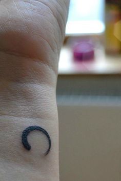 Zen Tattoo - This small tattoo may look simple, but it has a very deep meaning. This incomplete circle, which is traditionally thicker on one side, symbolizes zen. More so, this zen circle means enlightenment, the universe, and the strength we all have inside of all of us. Tattoo About Strength, Zen Tattoo, Viking Tattoo Symbol, Tattoo Placement Ideas, Unique Small Tattoo, Omerta Tattoo, Tattoo Quotes For Women, Semicolon Tattoo, Small Tattoos With Meaning