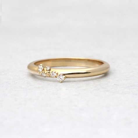 Ella flawlessly combines perfection and asymmetry. A tiny cluster of diamonds on a slim gold band. This ring represents a journey interrupted by clusters of magical moments.DETAILS- Cultivated, conflict free diamonds- Approximately .065 CTW- Band is approximately 2.1mm width x 1.7mm height- Handmade in our New York City studioSTONESWe are happy to offer alternative stones including natural diamonds. Please message/email us for details and pricing.VARIATIONS/CUSTOMIZATIONSWe can customize this ri Wedding Band Small Diamonds, Embedded Diamond Ring, Minimal Engagement Ring, Alternative Ring, Cluster Diamond Ring, Dainty Wedding Band, Handmade Gold Ring, Solid Gold Band, Cluster Rings